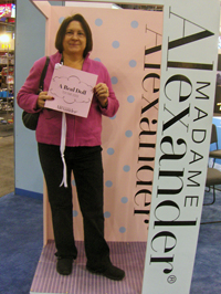 Carolyn DesRochers poses in a human-size replica of an Alexander doll box that is used for photo ops.