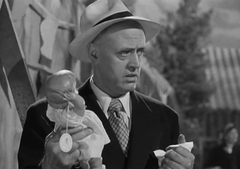 Alastair Sim as Commodore Gill, with the fatalistic baby doll