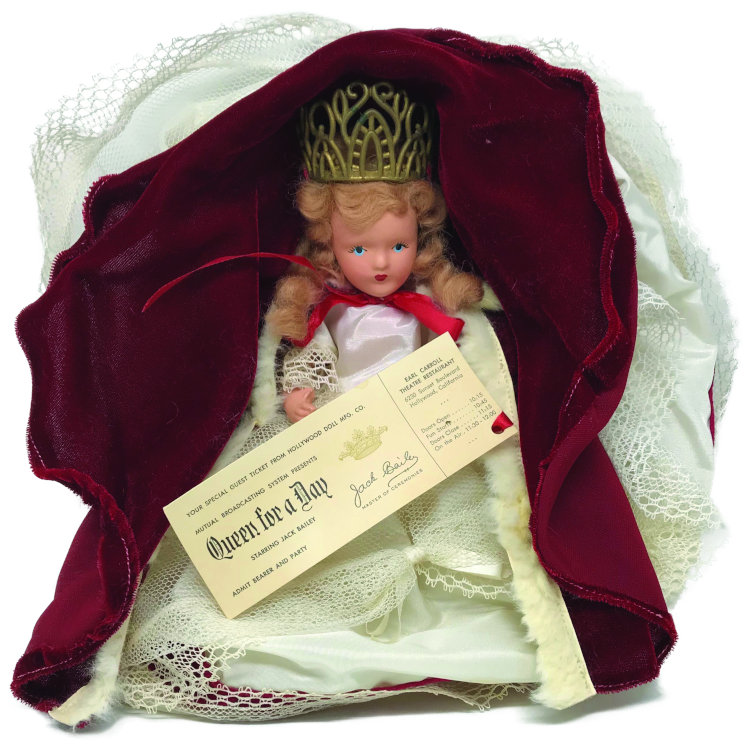 This 9-inch composition Queen for a Day doll had painted eyes. The blond doll is shown with a ticket for the television show.