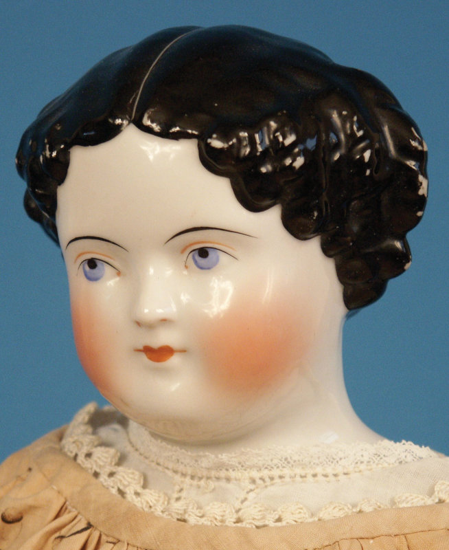 Closeup of 1860s china-head doll with modified flat-top hairdo.