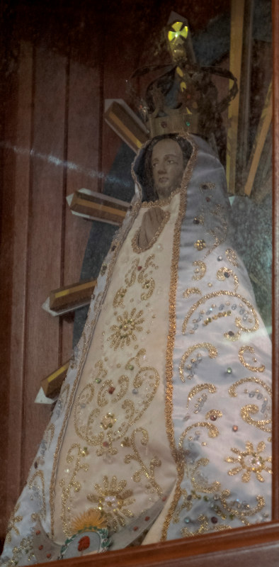 This small doll-like statue, high up on the cathedral wall in Santo Domingo, wears an exquisite robe embroidered in gold on silk. She was behind glass, so the image is not the best.