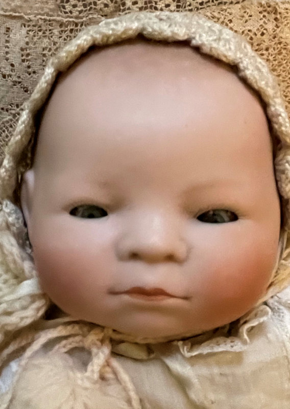 Closeup of a Grace Storey Putnam Bye-Lo Baby, dressed in contemporary vintage clothing.