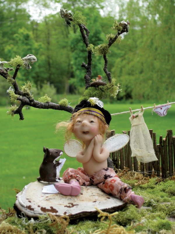 Closeup of the fairy doll outside the fairy house with a small mouse friend.