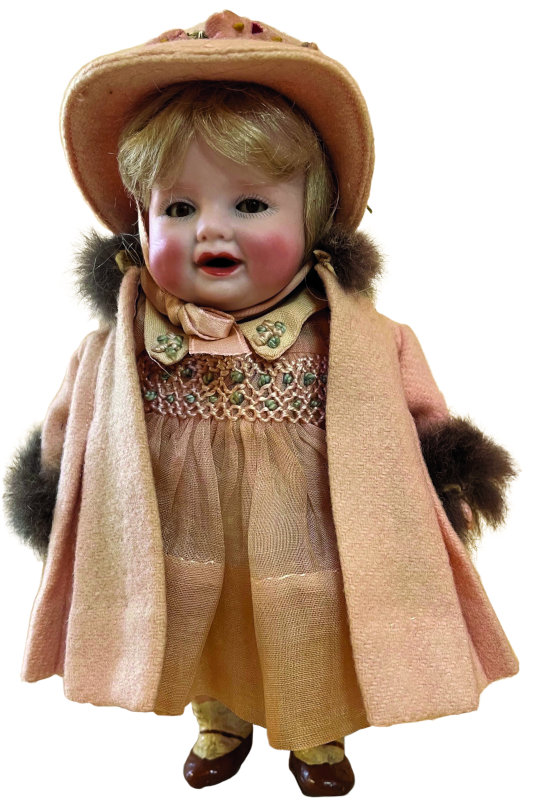 Bonnie Babe with socket head (ABG mold number 1393) on a five-piece composition chubby toddler body with molded shoes and socks. She was designed by Georgene Averill (also known as Madame Hendren) in 1926. Her bisque head features tiny sleeping glass eyes, chubby cheeks, dimples, pug nose, and open mouth with teeth. She is 7 inches tall. Photo courtesy of the Foulke Archives