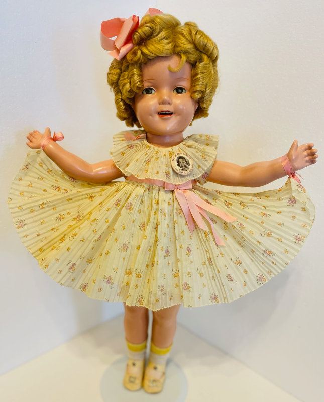This composition Shirley Temple doll from Ideal was released in 1934 and wears a dress from the movie "Baby Take a Bow."