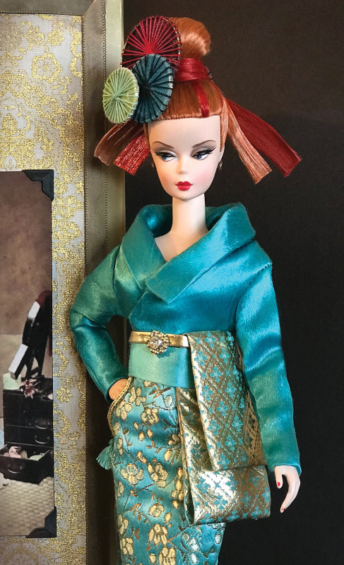 “Silkstone Mariko, a descendant of Japan’s highest courtesans from the Edo Period, borrows from the past but lives in the present, dressed in a modern silk and satin ‘kimono’ with unconventional pockets. Her custom two-tone hair is rerooted and styled by Seth Hanson. Mariko was made for the 2019 Grant-A-Wish, ‘Journey to Japan’ Doll Convention and is now in a private collection.”