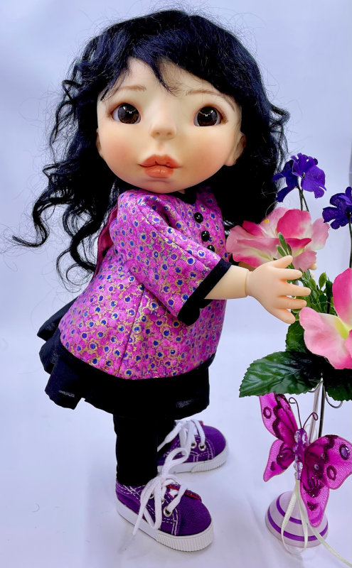 Doll wearing an Asian-style top, black pants and sneakers.