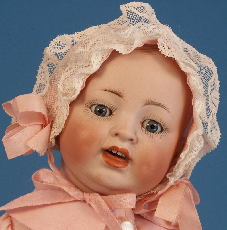 A 17-inch Hertel, Schwab & Co. smiling character baby mold 151, featuring molded hair, on a composition baby body.