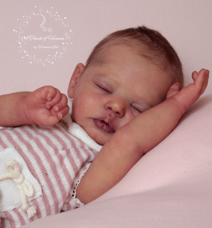 Realistic doll depicting a sleeping baby.
