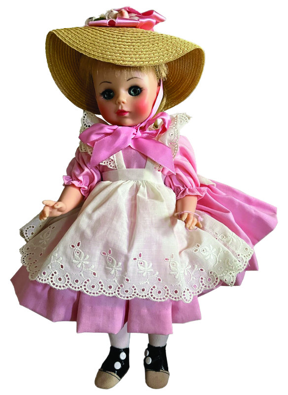 Doll wearing a pink and white dress with straw hat