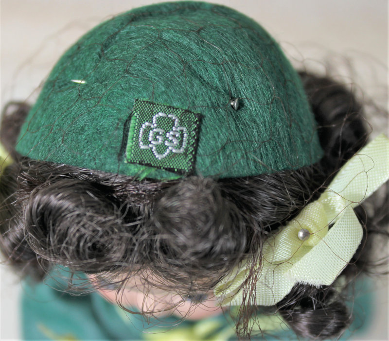 Closeup of the doll's Girl Scout hat with GS logo