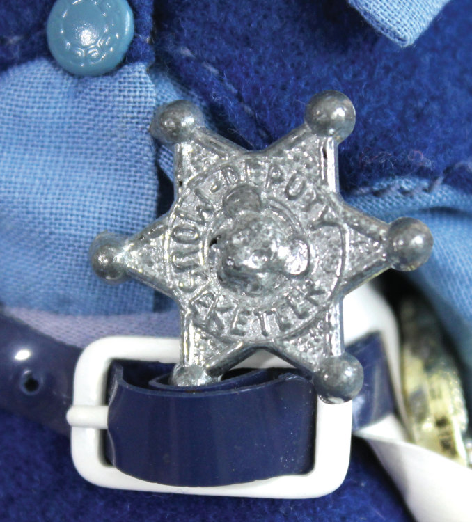 Closeup of six-pointed star badge that reads "Deputy Mouseketeer"
