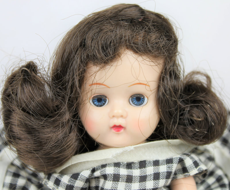 Closeup of Ginger doll with long brunette hair and blue eyes.