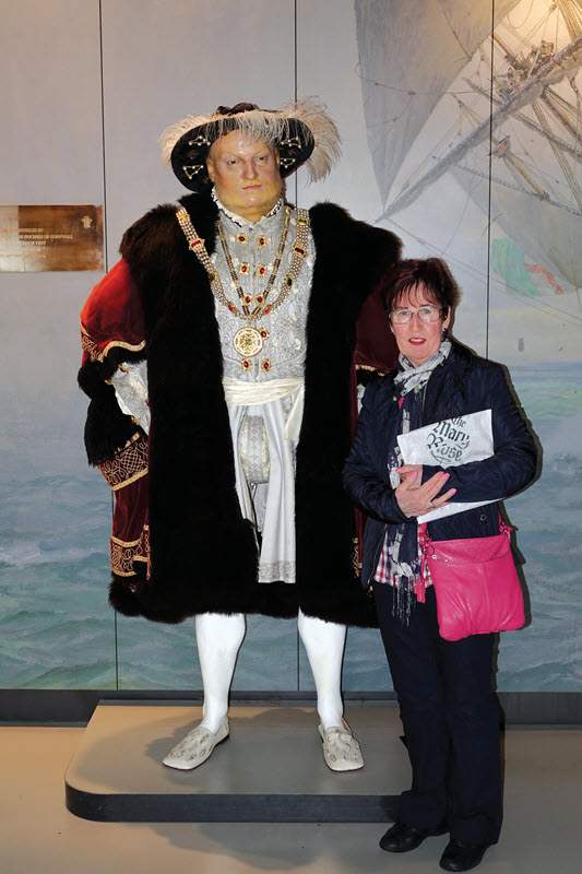Chris Poulten standing beside a life-sized statue of King Henry VIII.