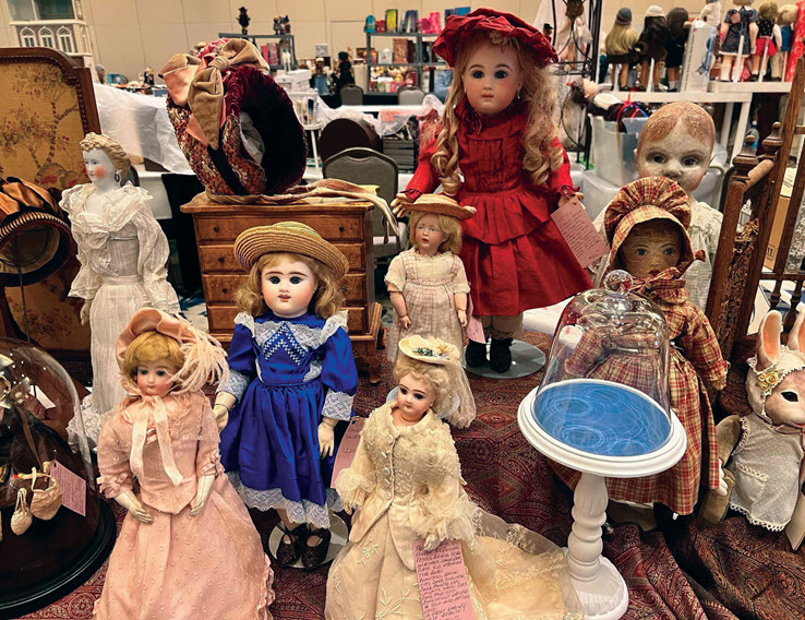 An assorted collection of antique dolls displayed on a table