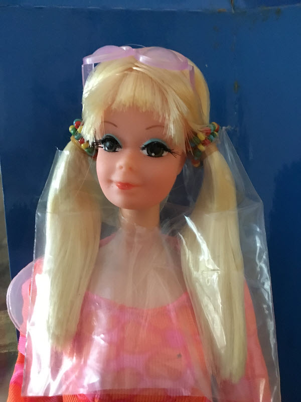 A close-up of Talking P.J. outside of her box. She's wearing pigtails with beads wrapped around them, her blond hair is wrapped in plastic, and she has pink eye glasses on top of her head