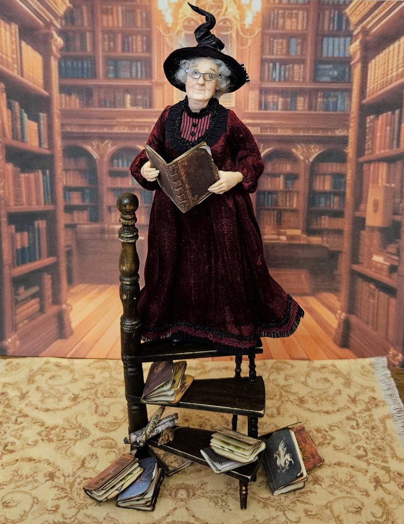 miniature doll witch on stairs with books in a library