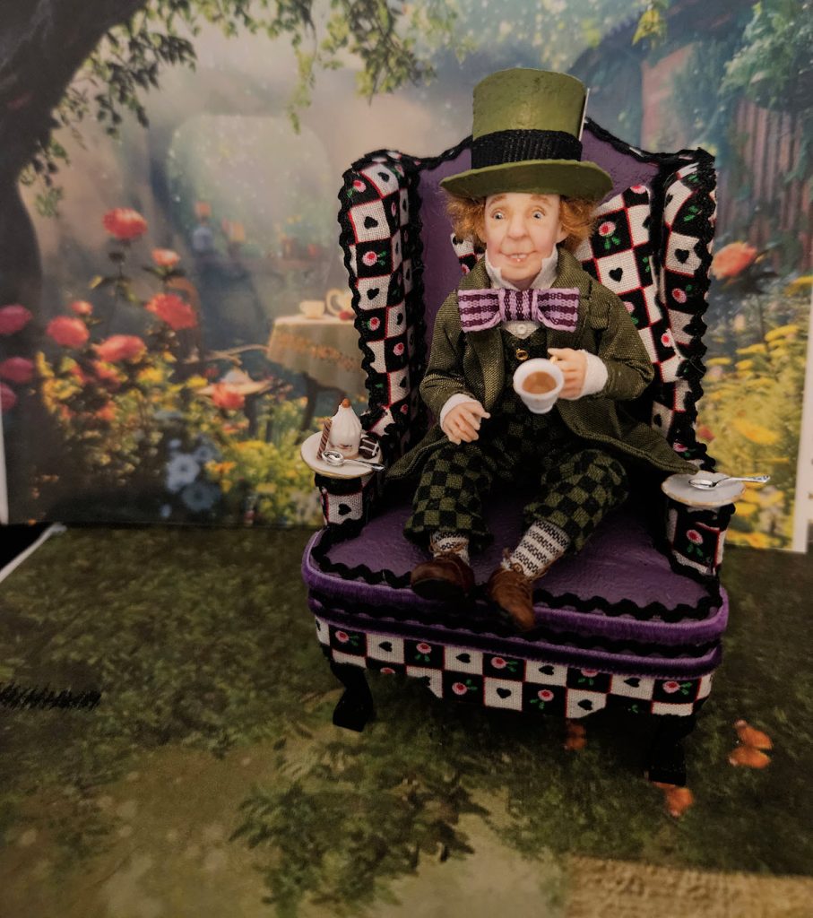 mad hatter miniature doll on purple chair with tea