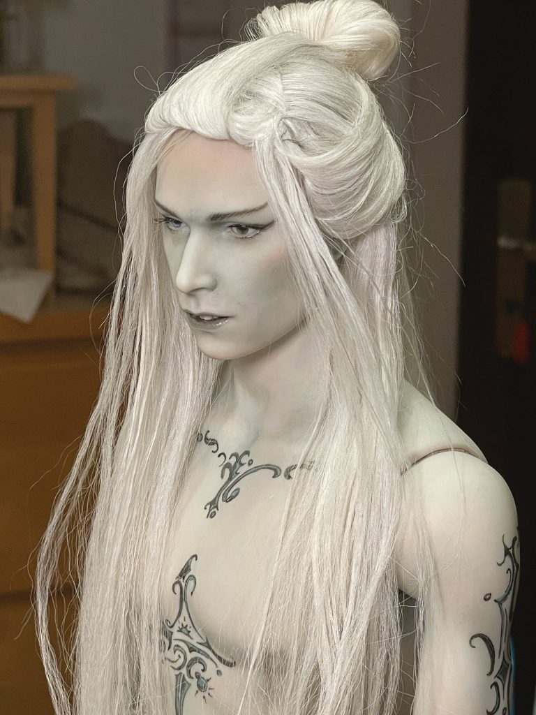 elf doll with pale skin, tattoos and long white hair