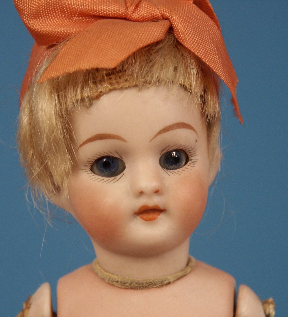 antique doll with orange bow