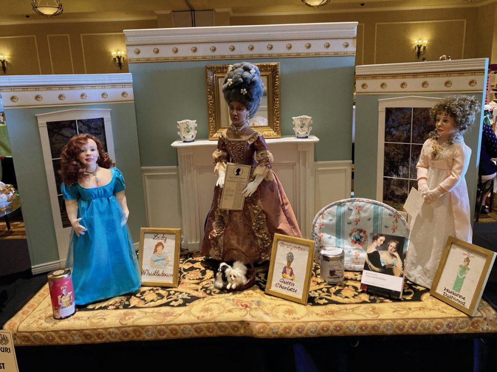 a collection of three historic dolls set on a table at a doll festival