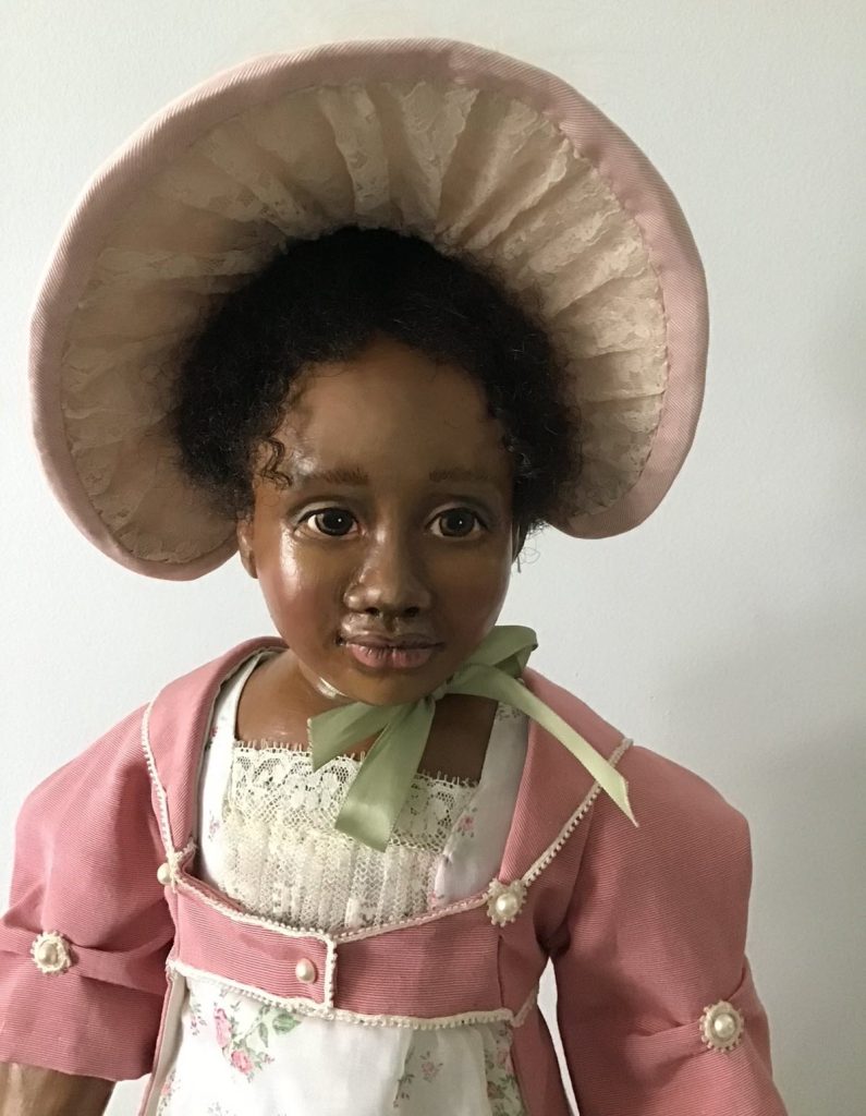 African American historical doll in pink dress and lace bonnet