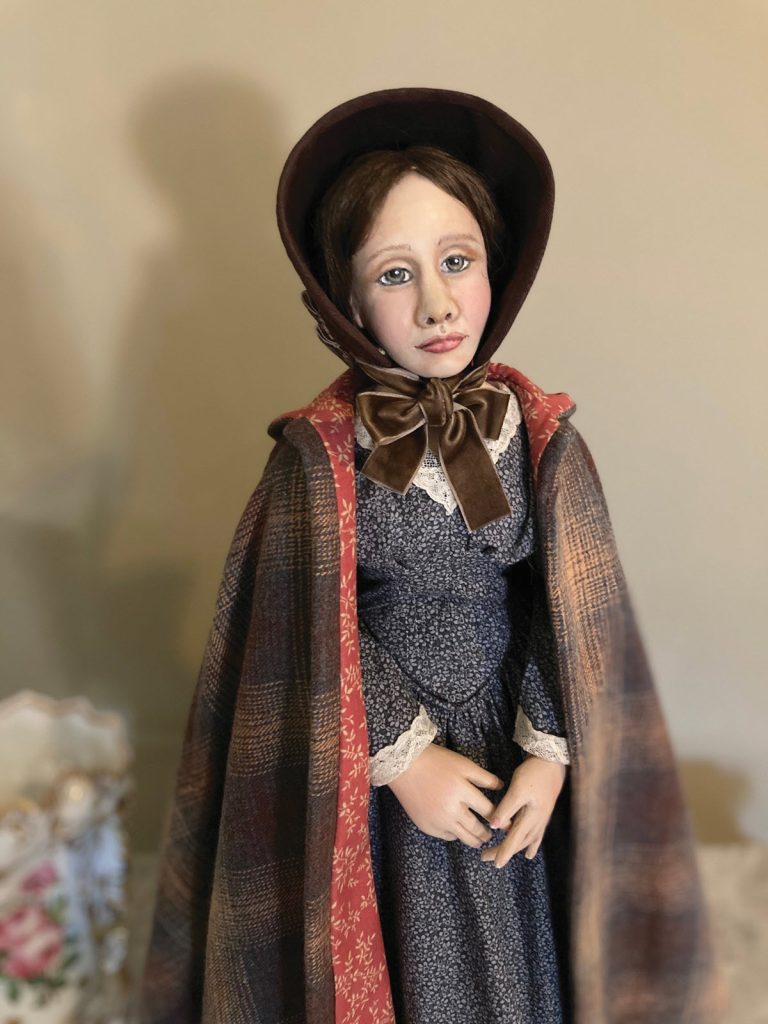 Jayne Ere doll in plaid coat, gray dress and brown bonnet